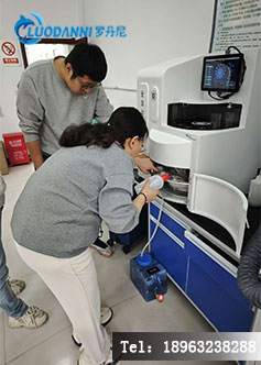 技术人员在煤矿粉尘智能监测与防控实验室中,利用全自动测定仪分析采煤工作面粉尘样本。