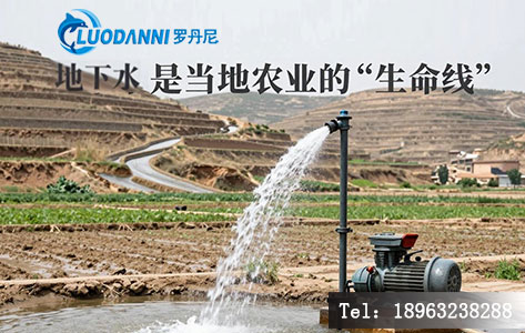 陕甘宁老区农田边的机井正在抽水灌溉,远处是层层梯田,水渠引向干涸的土地