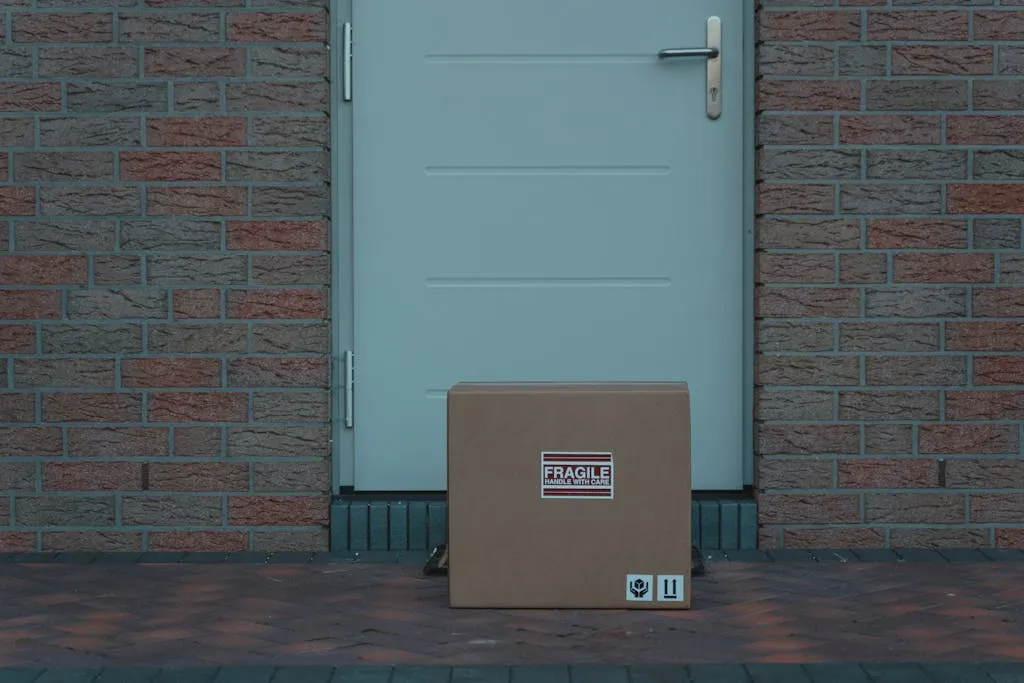 cardboard-box-placed-outside-a-brick-walled-entrance-labeled-fragile-for-delivery.-6170463-1024x683.jpg