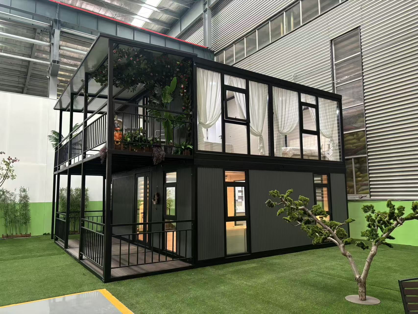 Two-storey prefabricated unit on display, glazed upper floor with terrace